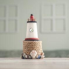 a small lighthouse made out of rope on top of a table