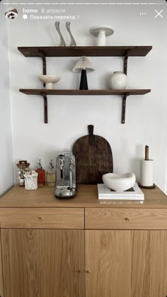 a wooden cabinet with shelves above it and various items on the top shelf in front of it