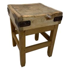 an old wooden stool with two leather straps on the seat and one foot resting on it's side