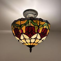 a stained glass light fixture hanging from the ceiling