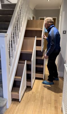 a man is standing in front of some stairs and looking at something on the ground