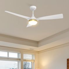 a bed room with a neatly made bed and a ceiling fan in the middle of it