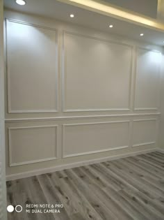 an empty room with white walls and wood floors