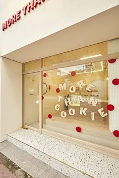 there is a store front with red polka dots on the window and it says more than cookie