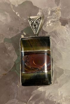 "3stones intarsia (tiger's eye/ Boulder opal/tiger's eye) with silver between. Stone 1 1/4\" tall. 1 7/8\" tall total. Back of pendant has 2 pine trees carved into it and a moon etched in." Collectible Brown Jewelry With Natural Stones, Brown Natural Stones Jewelry For Collectors, Brown Polished Agate Jewelry, Spiritual Brown Cabochon Jewelry, Artisan Brown Inlay Jewelry, Unique Brown Jewelry With Inlay, Artisan Brown Rectangular Jewelry, Unique Brown Cabochon Jewelry, Morgantown Wv