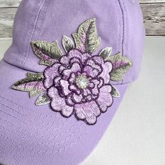 a purple hat with a flower embroidered on it