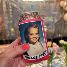 a woman holding up a can with a picture on it