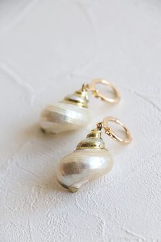 Natural sea shell gold hoop earrings in 18k gold plated.  Earrings hoop size: 12mm dia  Shell size: about 25-30mm Metal component: 18k gold plated brass base This listing is for a pair of earrings. ﹎﹎﹎﹎﹎﹎﹎﹎﹎﹎﹎﹎﹎﹎﹎﹎﹎﹎﹎﹎﹎﹎ ▲ Care instruction:  Please remove it before bathing or swimming.  Avoid your jewelry touching chemical such as hairsprays or perfumes.  Using soft cloth to clean your jewelry every time after wearing it, and store it in a dry and cool place. ▲ Gift packaging:  All products will Gold Mother Of Pearl Shell, Gold Shell Drop Earrings, Ocean-inspired, Gold Shell With Matching Earrings, Gold Ocean-inspired Shell Drop Earrings, Gold Mother Of Pearl Shell-shaped Earrings, Shell-shaped Gold Shell Earrings, Gold Shell-shaped Shell Earrings, Gold Shell-shaped Earrings, Elegant Shell-shaped Gold Hoop Earrings