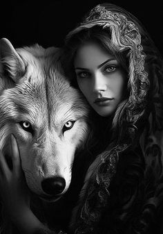 a woman holding a wolf in her arms with the wolf's head on her shoulder