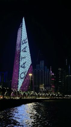 a very tall building that is lit up in the night sky with lights on it