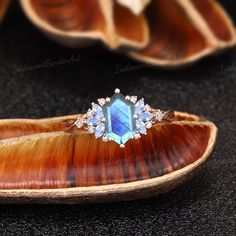 a blue stone ring sitting on top of a shell