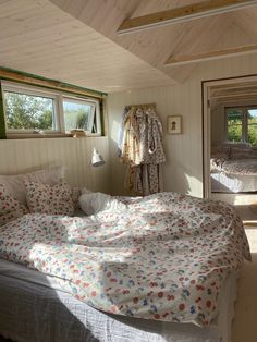 a bed in a room with two windows and a blanket on top of the bed