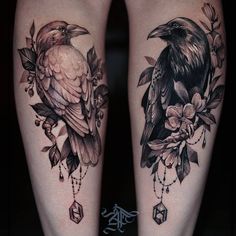 two black birds sitting on each other's legs with flowers and beads around them