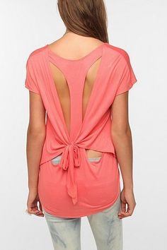 the back of a woman's pink top with cutouts