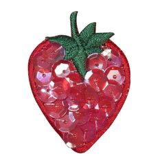 a red strawberry shaped brooch with lots of buttons on it's back side