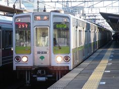 a subway train pulling into the station with its lights on