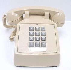 an old style telephone sitting on top of a white table