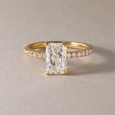 an engagement ring with a princess cut diamond and pave set diamonds on the sides