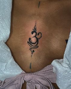 a woman's stomach with a tattoo on her chest and an ombrephant