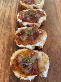 three pieces of bread with jelly and cheese on them sitting on a wooden table top