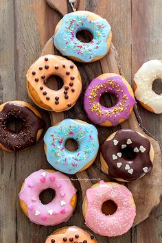 six donuts are arranged on a wooden board