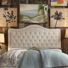 a bed with a white headboard sitting next to pictures on the wall above it