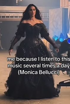 a woman in a long black dress with her hands on her hips and the words, me because i listen to this music several times a day monica belluci