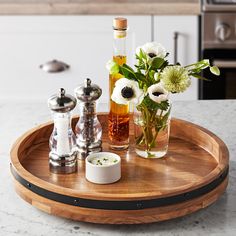 a wooden tray with flowers and bottles on it