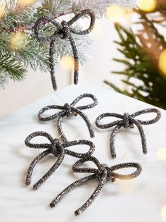 three black bows hanging from a christmas tree