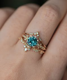 a woman's hand with a ring on it and a blue stone in the middle