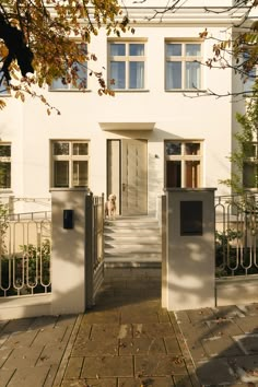 a white house with a dog in the door and steps leading up to it's entrance