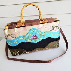 This Pretty Mid Size Handbag Is By Preston And York. It Is Actually New And Unused However It Only Has A Part Of The Price Tag Left Attached To It. The Fabric And Smooth And Satin Like With An Embroidered Vine Design. Bag Has Plenty Of Space Inside With A Large Zipper Pouch In The Center With 2 Larger Open Pouches On Either Side. There Is Also A Zip Pouch Along One Side, A Tiny Mirror, And An Optional Cross Strap. Bag Measures 9" Tall X 15" Wide And A Depth Of 5". The Only Issue I See Is A Very Brown Embroidered Rectangular Bag, Embroidered Brown Rectangular Satchel, Brown Embroidered Rectangular Satchel, Embroidered Brown Shoulder Bag For Shopping, Brown Embroidered Shoulder Bag For Shopping, Embroidered Brown Tote Satchel, Vintage Blue Embroidered Bag, Brown Embroidered Tote Satchel, Blue Tote Bag With Bamboo Handle