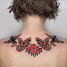 the back of a woman's neck with birds and flowers on her upper part