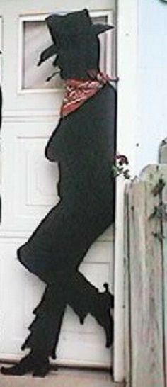 the silhouette of a man in a top hat and scarf is on the front door of a house