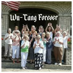 a group of people standing in front of a building with the words wu - tang forever