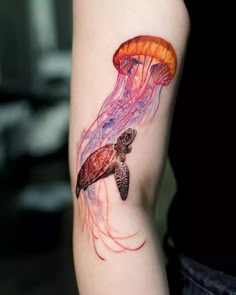 a woman with a tattoo on her arm that has a jellyfish and a turtle in it