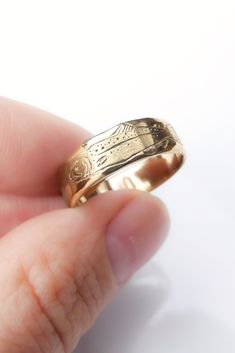 a person holding a gold ring in their hand