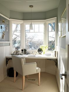 a chair sitting in front of a window next to a desk