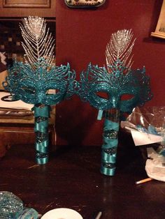 three vases with blue ribbons and bows are sitting on a table in front of a red wall