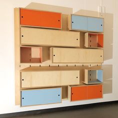 the shelves are made out of plywood and painted orange, blue, and white