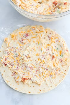 two tortillas covered in cheese on top of a white counter next to each other