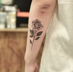 a rose tattoo on the left arm