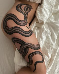 a woman's leg with a snake tattoo on it