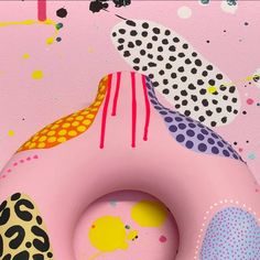 an inflatable donut is sitting on a pink surface with dots and shapes