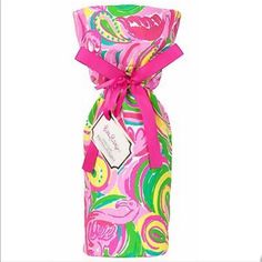 a bottle wrapped in pink and green fabric with a bow on the top that is decorated with colorful swirls