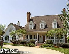 a large white house sitting on top of a lush green field