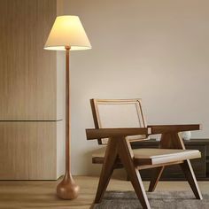 a lamp that is sitting next to a chair in a room with a table and chairs