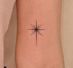 a small star tattoo on the right side of the leg, with an arrow in the center