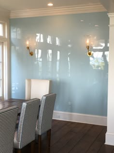 a dining room with blue walls and wooden floors