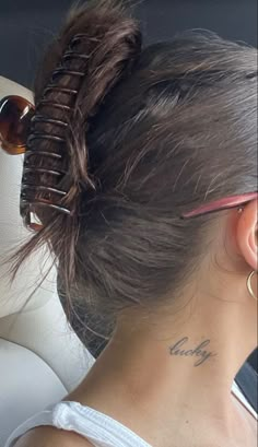 a woman with a tattoo on her neck sitting in a car